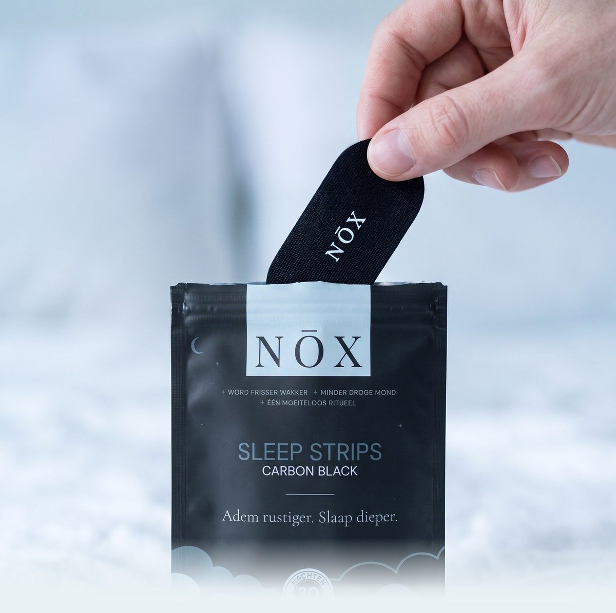 Een hand neemt een strip uit de NŌX pouch